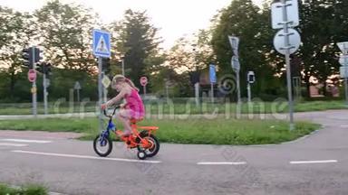 女孩在操场上骑<strong>自行车交通</strong>。 夏天骑<strong>自行车</strong>的小女孩