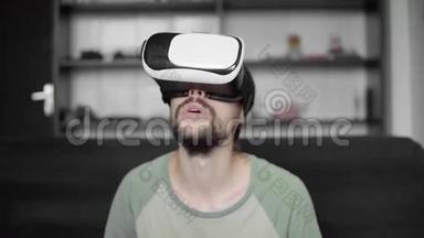 年轻留胡子的嬉皮士用他的<strong>VR</strong>耳机显示虚拟现实游戏或观看360视频，并试<strong>图</strong>