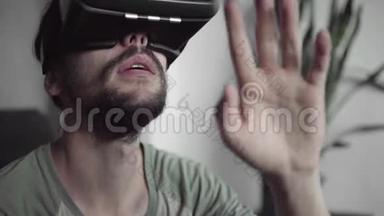 年轻留胡子的嬉皮士用他的VR耳机显示虚拟现实游戏或观看360视频，并试图