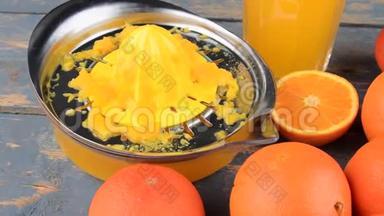 橘子，橘子，一杯橙汁和手动柑橘吱吱在蓝色的木制背景。 橘子切成两半