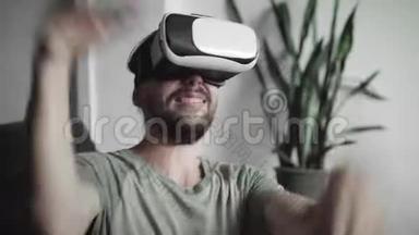 年轻留胡子的嬉皮士用他的<strong>VR</strong>耳机显示虚拟现实游戏或观看360视频，并试<strong>图</strong>