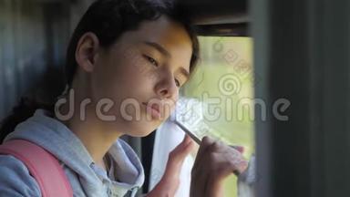 悲伤的女孩望着火车窗外。 旅游运输铁路概念。 生活方式少女错过旅行