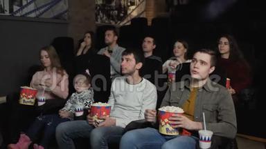 人们在电影院里吃爆米花和看电影
