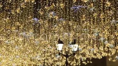 圣诞节和新年假期照明户外城市街道在夜间。 金光闪闪的花环