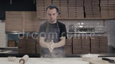 面包师用擀面杖把面团摊开，年轻厨师做披萨送外卖