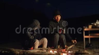 孩子们微笑，孩子们喝茶，青少年坐在篝火旁。 旅行徒步旅行冒险露营冒险野营