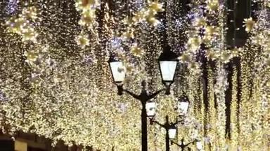 圣诞节和新年假期照明户外城市街道在夜间。 金光闪闪的花环