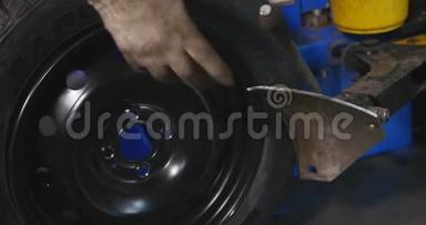 专业的汽车维修人员在汽车维修服务延时内更换车轮上的轮胎. 下一个机械平衡轮
