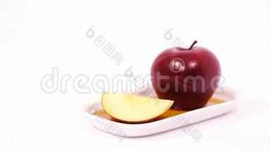 白色盘子上的红<strong>苹果</strong>和红<strong>苹果</strong>切片，白色背景上分离出<strong>蜂蜜</strong>
