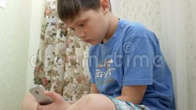 青少年在<strong>家中</strong>坐在地板上兴奋地玩智能手机游戏
