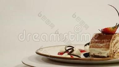 木制桌子上草莓芝士蛋糕的俯视图。 一块巧克力蛋糕，上面有草莓装饰。 一块
