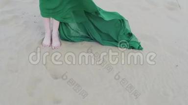 穿绿色衣服的美女站在沙丘上