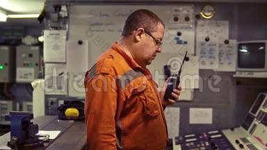 轮机工程师在发动机控制室进行无线电通讯