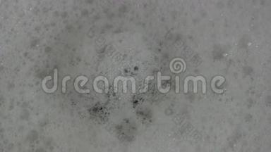 泡泡水从浴缸的塞子孔流下来。