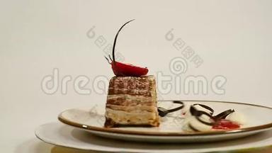 木制<strong>桌子</strong>上草莓芝士蛋糕的<strong>俯视</strong>图。 一块巧克力蛋糕，上面有草莓装饰。 一块