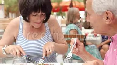 高级情侣一起在户外餐厅享用美食