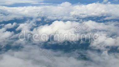 4K. 透过飞机窗户的鸟瞰。 蓝天背景下美丽的白云。 乘飞机旅行。