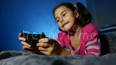 青少年女孩玩<strong>儿童</strong>便携式<strong>电子</strong>在线游戏一个控制台孩子晚上在室内