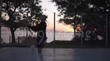 年轻女子篮球运动员在篮球场户外训练。 清晨黄昏