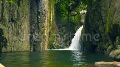 雨林中的山瀑布。 瀑布流出来的水流在河中的大石头上。