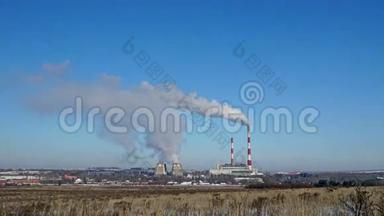 火力发电厂或地平线上有吸烟烟囱的工厂。 污染烟雾进入晴朗的蓝天。