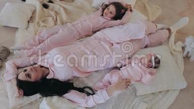 母亲和女儿穿着粉红色睡衣的新生婴儿在<strong>平安</strong>夜