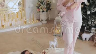 母亲和女儿穿着粉红色睡衣的新生婴儿在<strong>平安夜</strong>