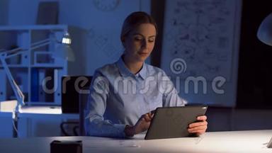 有平板电脑的女商人在夜间办公室<strong>工作</strong>