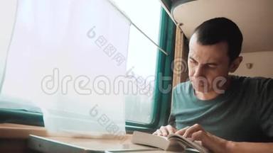 人在火车<strong>长途旅行</strong>中看书.. 铁路旅游概念教练火车之旅.. 从窗户看到美丽的景色
