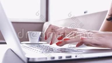 咖啡馆里的女孩。 双手触摸笔记本电脑键盘上的打字