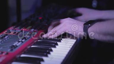 音乐家在键盘上弹奏合成器钢琴键。 音乐家在音乐会舞台上演奏乐器