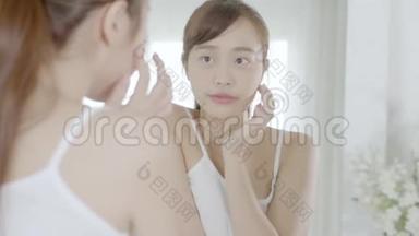 美丽的肖像年轻的亚洲女人微笑着看着镜子检查皮肤护理白种人在卧室健康