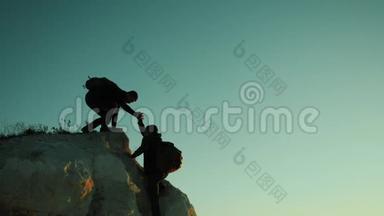 两个男子协同游客爬上一座山。 徒步旅行者徒步旅行冒险登山日落攀登
