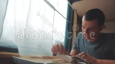 人在火车<strong>长途旅行</strong>中看书.. 铁路旅游概念教练火车之旅.. 从窗户看到美丽的景色