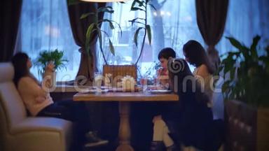 孩子们一家人在咖啡馆里吃披萨。 青少年在咖啡厅慢动作视频中吃快餐