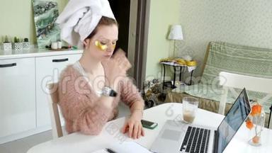 有魅力的女商人在家里涂化妆品，在笔记本电脑后面工作