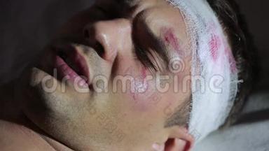 头部受伤的人躺在床上。 <strong>包扎</strong>好的头。 他脸上的瘀伤。
