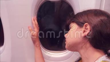 <strong>航空飞机</strong>概念。 年轻的女孩看着坐在窗边的飞机。 生活方式之夜的航班