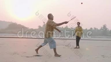 活跃的老夫妇在海滩上打太极圆球