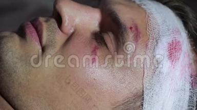 头部受伤的人躺在床上。 包扎好的头。 他脸上的瘀伤。
