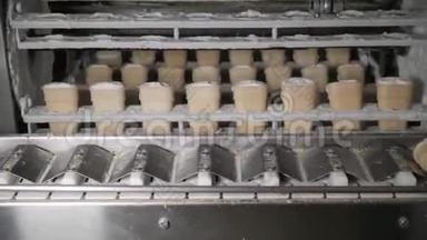 该输送机自动生产线生产冰淇淋锥。 晶片杯和锥。 大型工业生产。 A.
