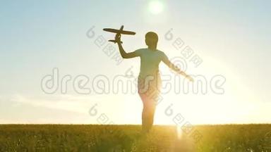 快乐<strong>的</strong>女孩带着玩具飞机在夕阳下<strong>的</strong>田野上<strong>奔跑</strong>。 孩子们玩玩具飞机。 青<strong>少年的</strong>梦想