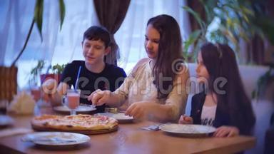 一家群孩子在咖啡馆里吃披萨。 青少年在咖啡厅慢动作视频中吃快餐