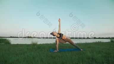 年轻女孩穿着<strong>运动</strong>服，早上在湖里和<strong>科普</strong>空间做瑜伽