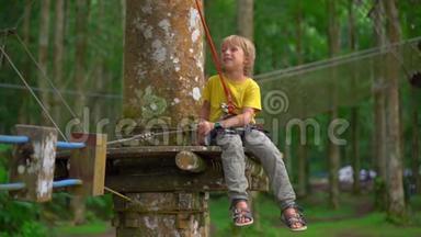 在森林探险公园的一条路线上，一个穿着安全装备的小男孩被拍到了超慢镜头。 室外娱乐中心