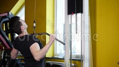 一个有运动<strong>身材</strong>的人在健身房的模拟器里做运动
