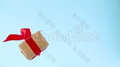 礼品盒，红色丝带在蓝色背景上旋转。 360度旋转。 无缝环。 零重力。 悬浮。 共空间。