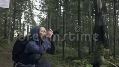 <strong>游客</strong>在<strong>森林</strong>中拍摄风景。 一个白种人的女人拍摄漂亮的魔术外观。 女孩拍照视频
