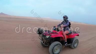 在埃及沙漠里，女人骑着一辆四方自行车。 动中的动态视图..