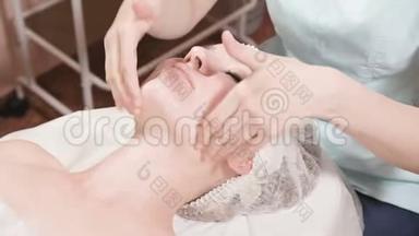 戴着面具和手套的女美容师给一个有魅力的女人做一个有益健康的面部按摩。 <strong>新一代</strong>
